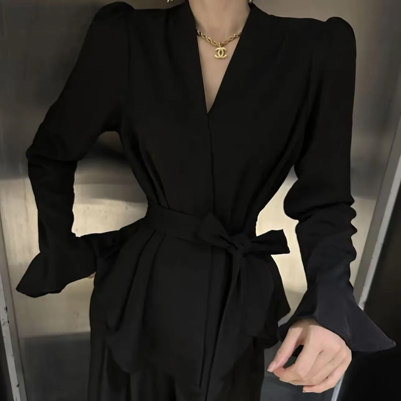 Women's black French-style shirt with long bell sleeves, an irregular collar, and a tied front detail.