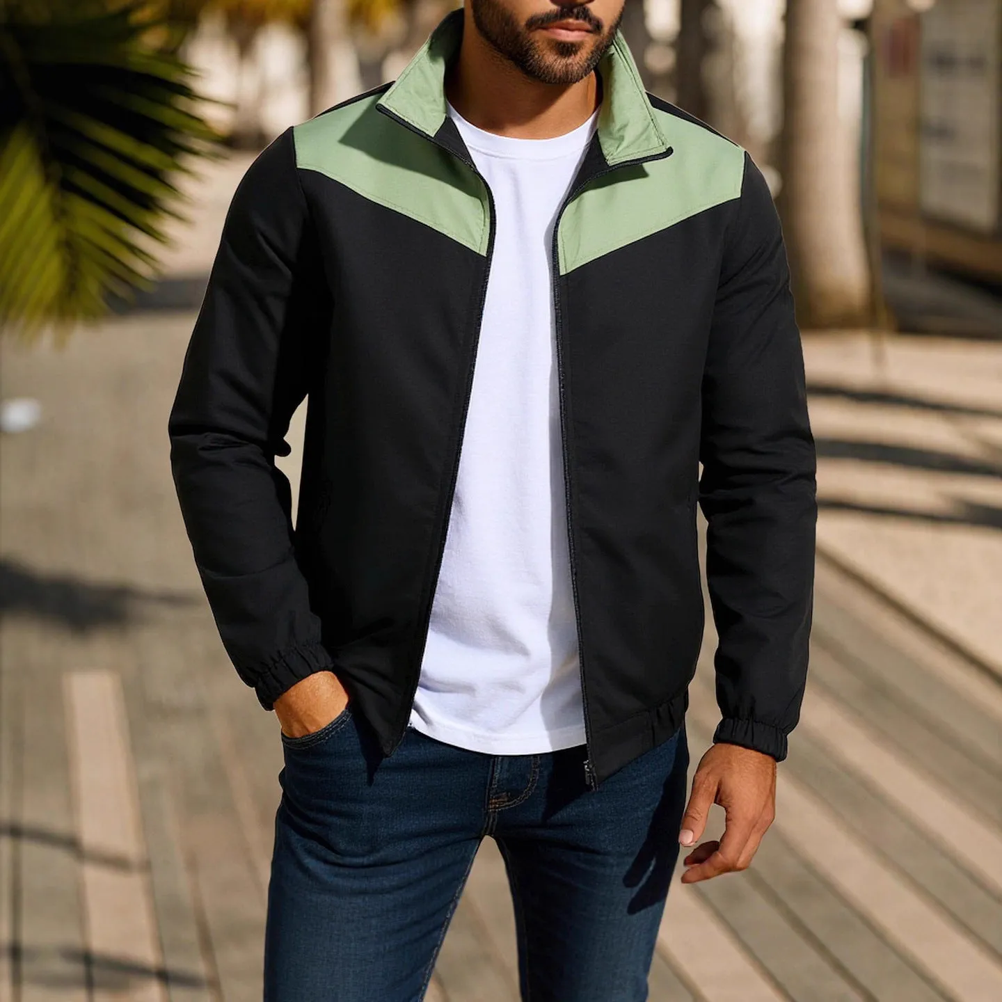 Man wearing a green windproof jacket with a high collar and front zip.