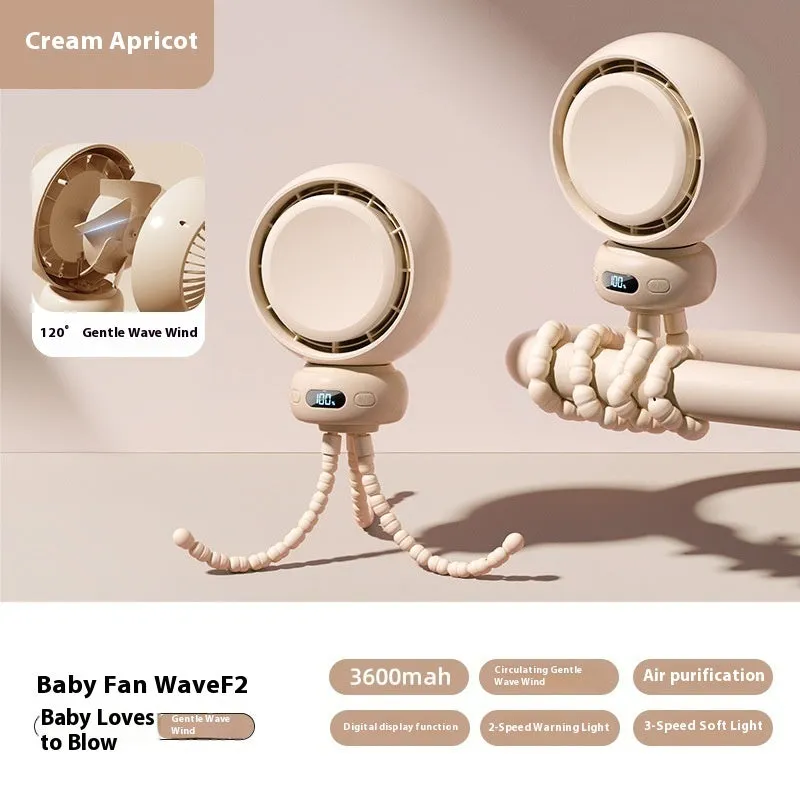 A beige portable clip-on fan with three blades, mounted on a stroller handle, showing its rotating head.