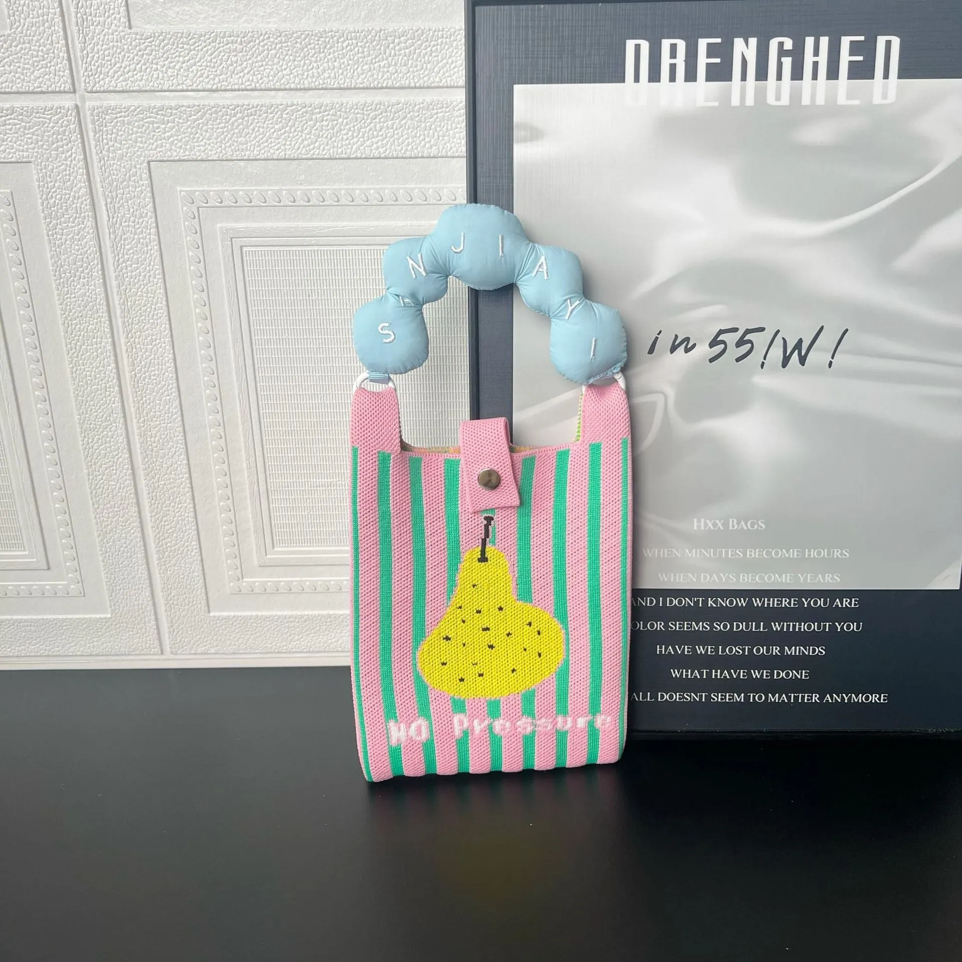 Square-shaped knitted polyester messenger bag featuring a cartoon character design, shown with an open outer pocket and adjustable shoulder strap.