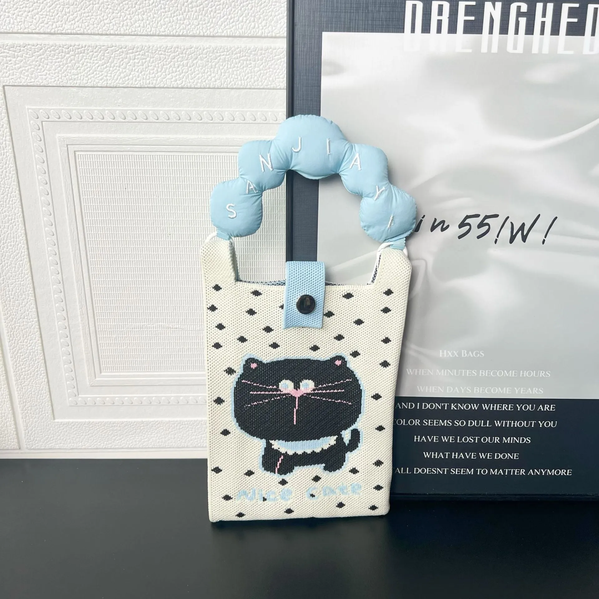Square-shaped knitted polyester messenger bag featuring a cartoon character design, shown with an open outer pocket and adjustable shoulder strap.