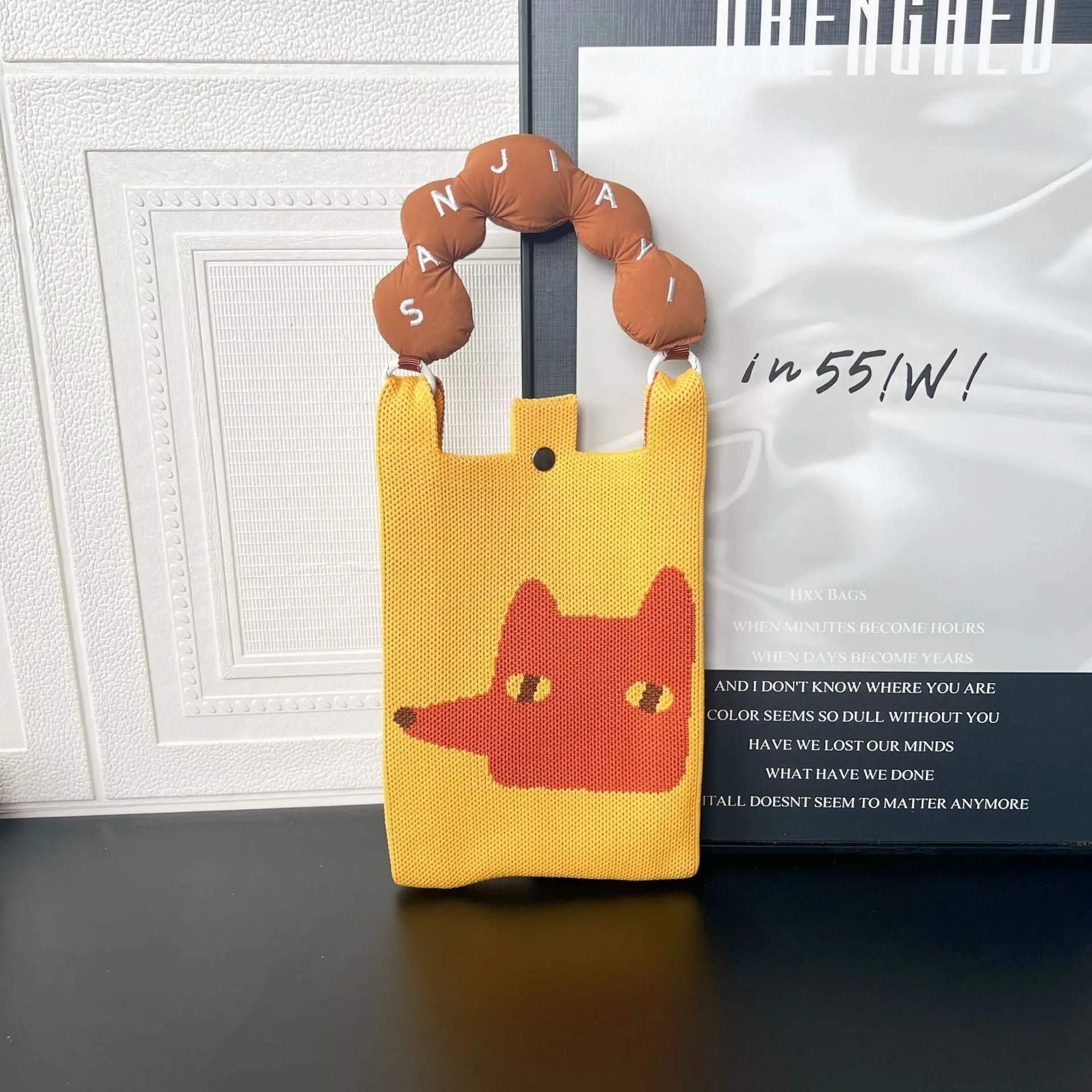 Square-shaped knitted polyester messenger bag featuring a cartoon character design, shown with an open outer pocket and adjustable shoulder strap.