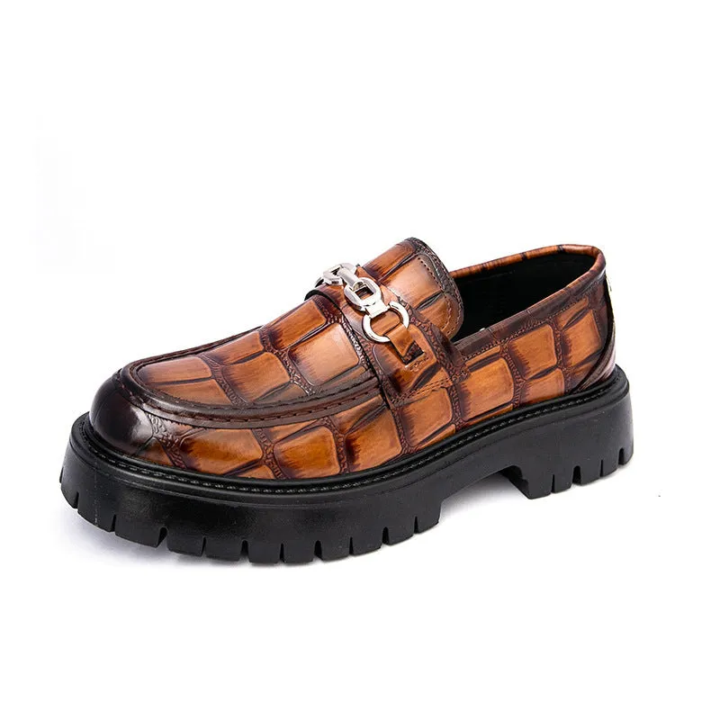 Men's black crocodile pattern loafers with a flat platform sole on a plain background.