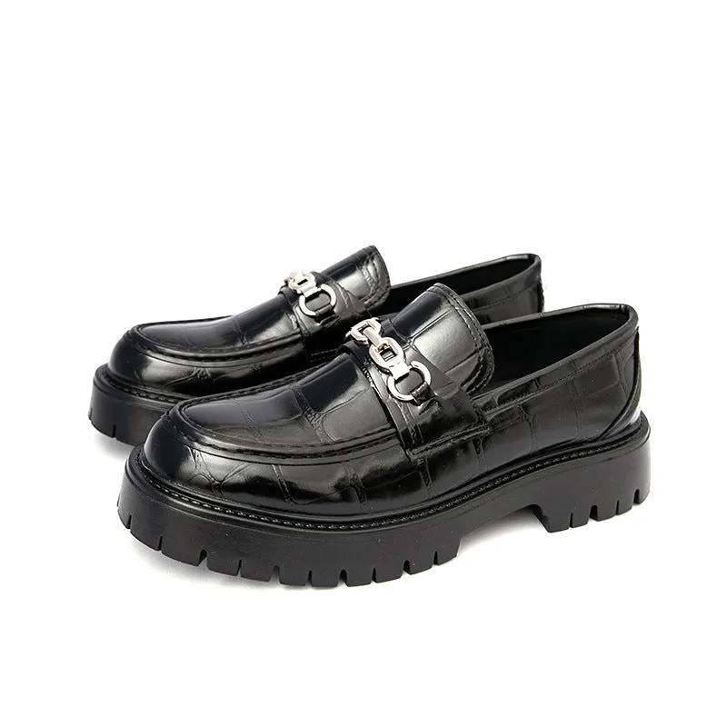 Men's black crocodile pattern loafers with a flat platform sole on a plain background.