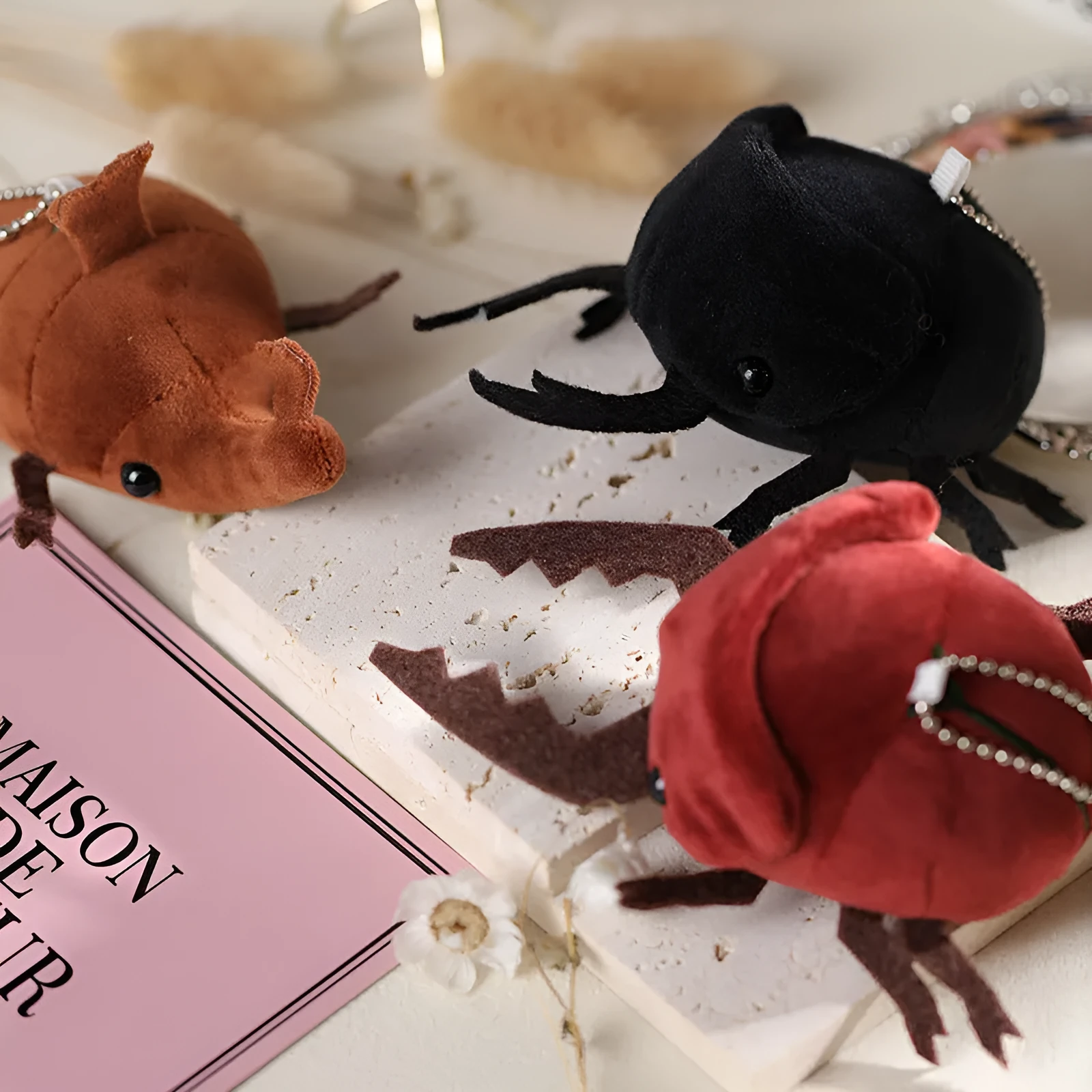 Small black plush rhinoceros beetle doll pendant with 10cm height on a white background.