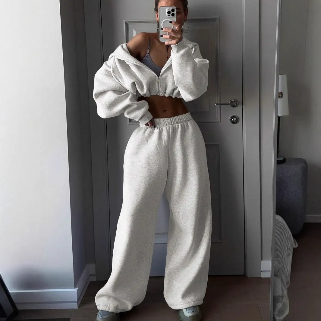 Man wearing a long sleeve sweater and matching trousers from a grey two-piece sports leisure suit set.