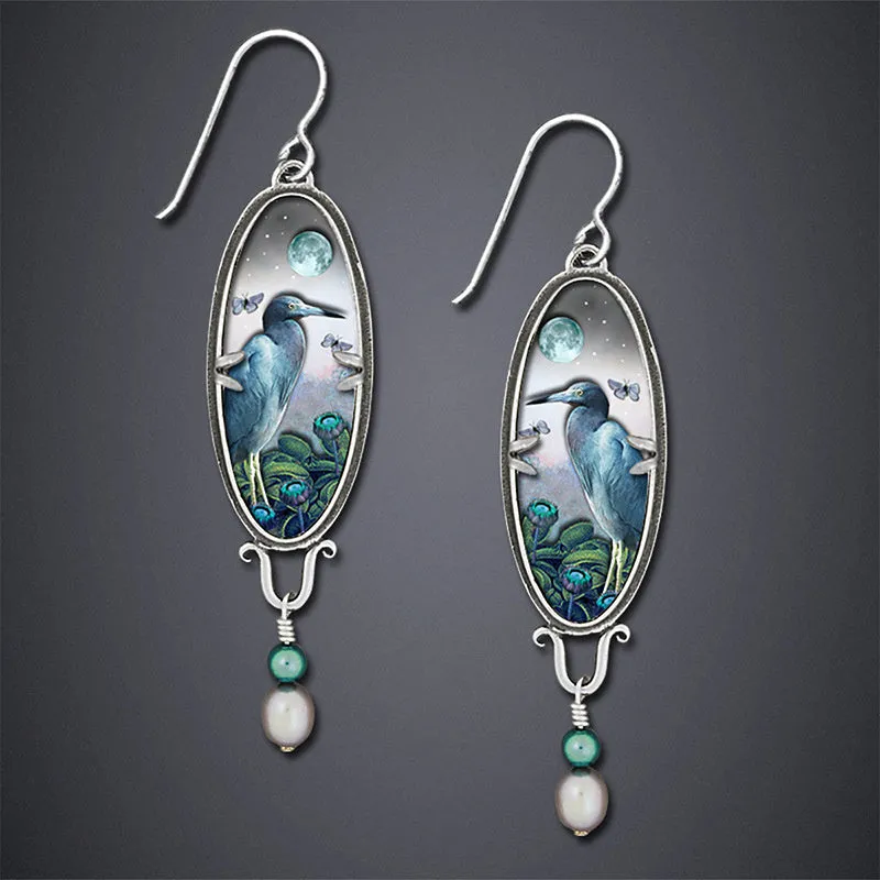Silver drop earrings with a detailed bird and flower motif on a retro design.