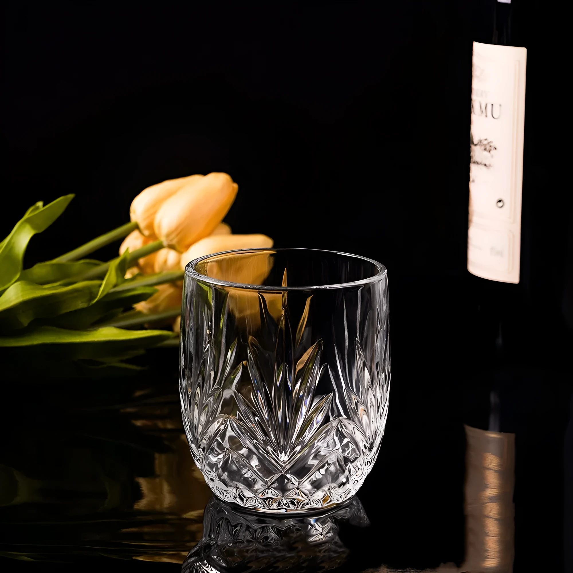 Clear crystal whiskey shot glass with a thick bottom on a wooden surface.