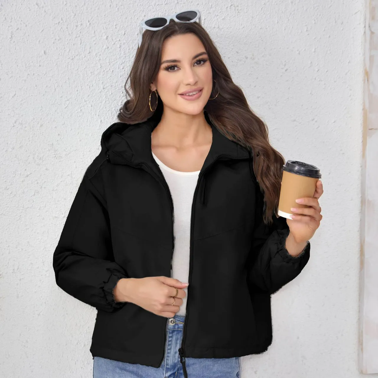 Grey women's loose-fit hooded polyester shell jacket with long sleeves on a hanger.