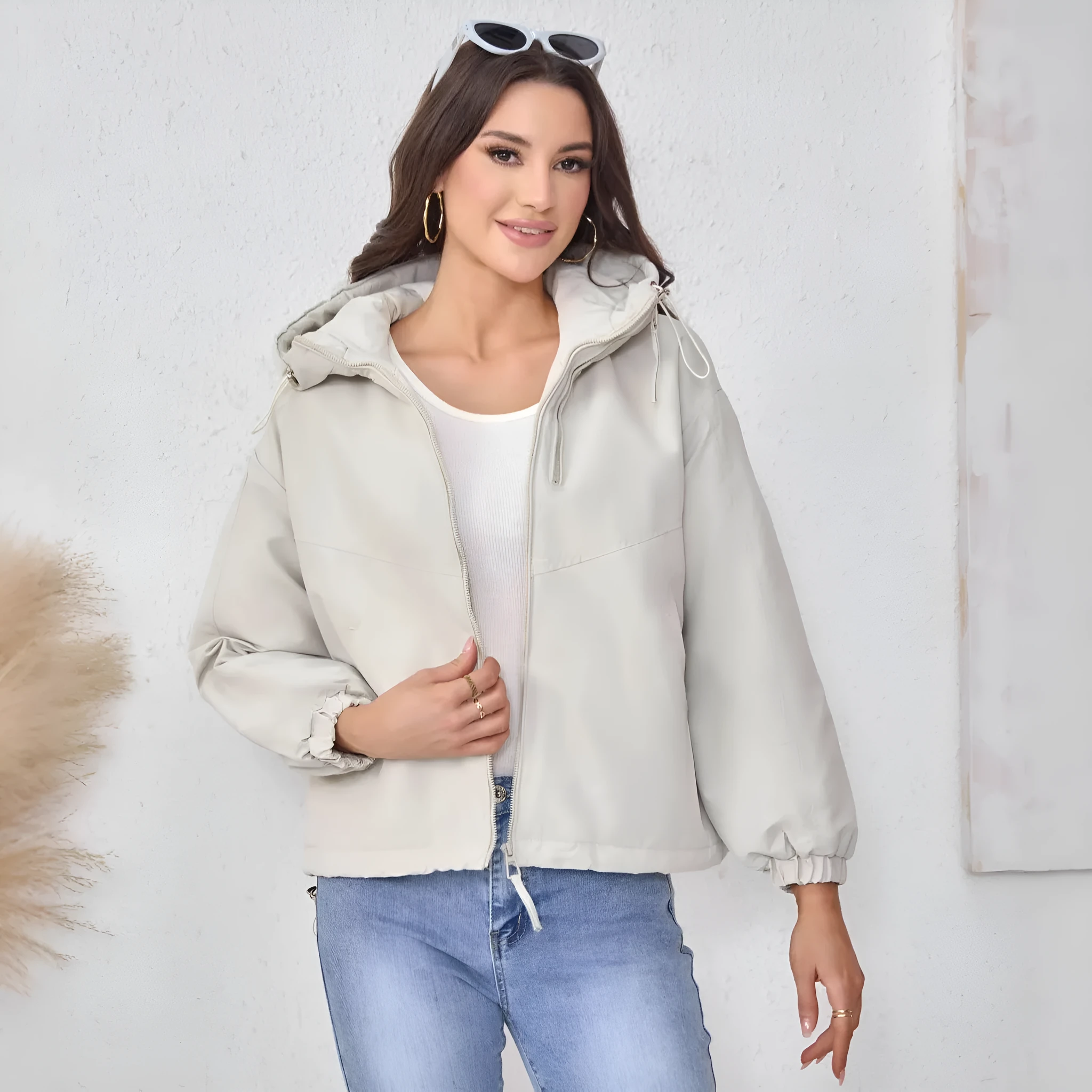 Grey women's loose-fit hooded polyester shell jacket with long sleeves on a hanger.