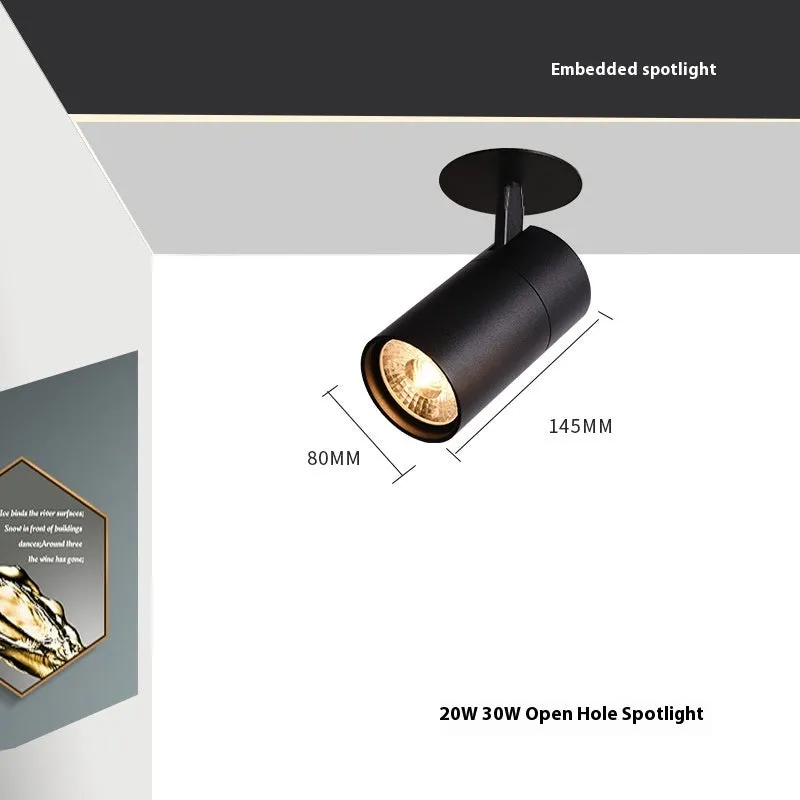 Black recessed cylinder LED spotlight installed in a ceiling track, showing adjustable head.