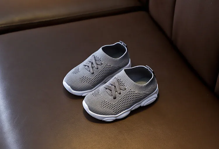 Children's white fabric lazy shoe with a non-slip rubber sole, shown on a foot.