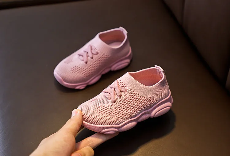 Children's white fabric lazy shoe with a non-slip rubber sole, shown on a foot.