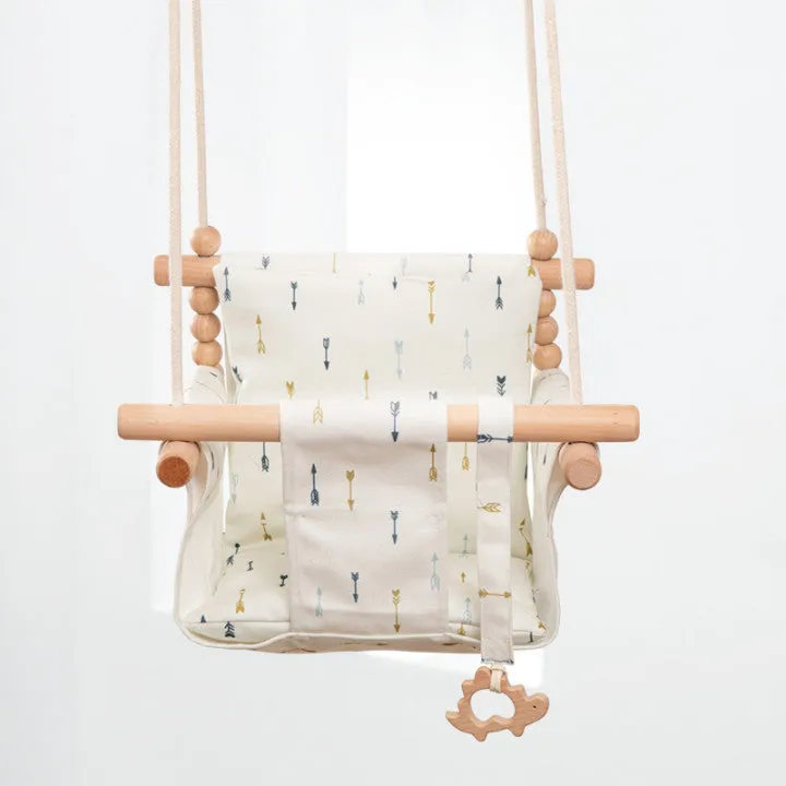 Cotton canvas baby swing chair with wooden seat and cushion hanging indoors
