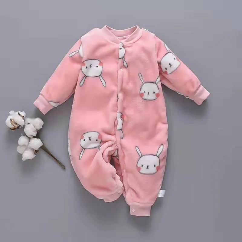 Baby wearing a long-sleeved flannel romper in a pink bunny head print, showcasing the 100% cotton fabric.