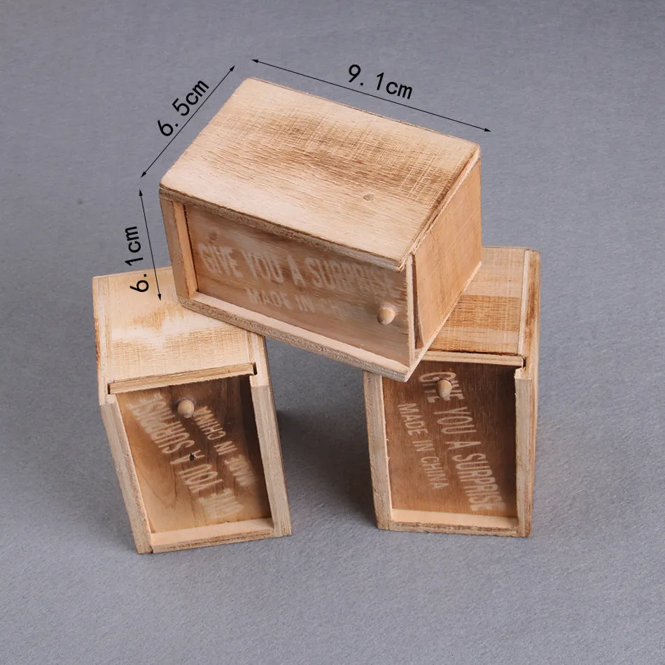A closed wooden prank scare box measuring 9.1 cm, with a random lifelike animal inside ready to jump out.