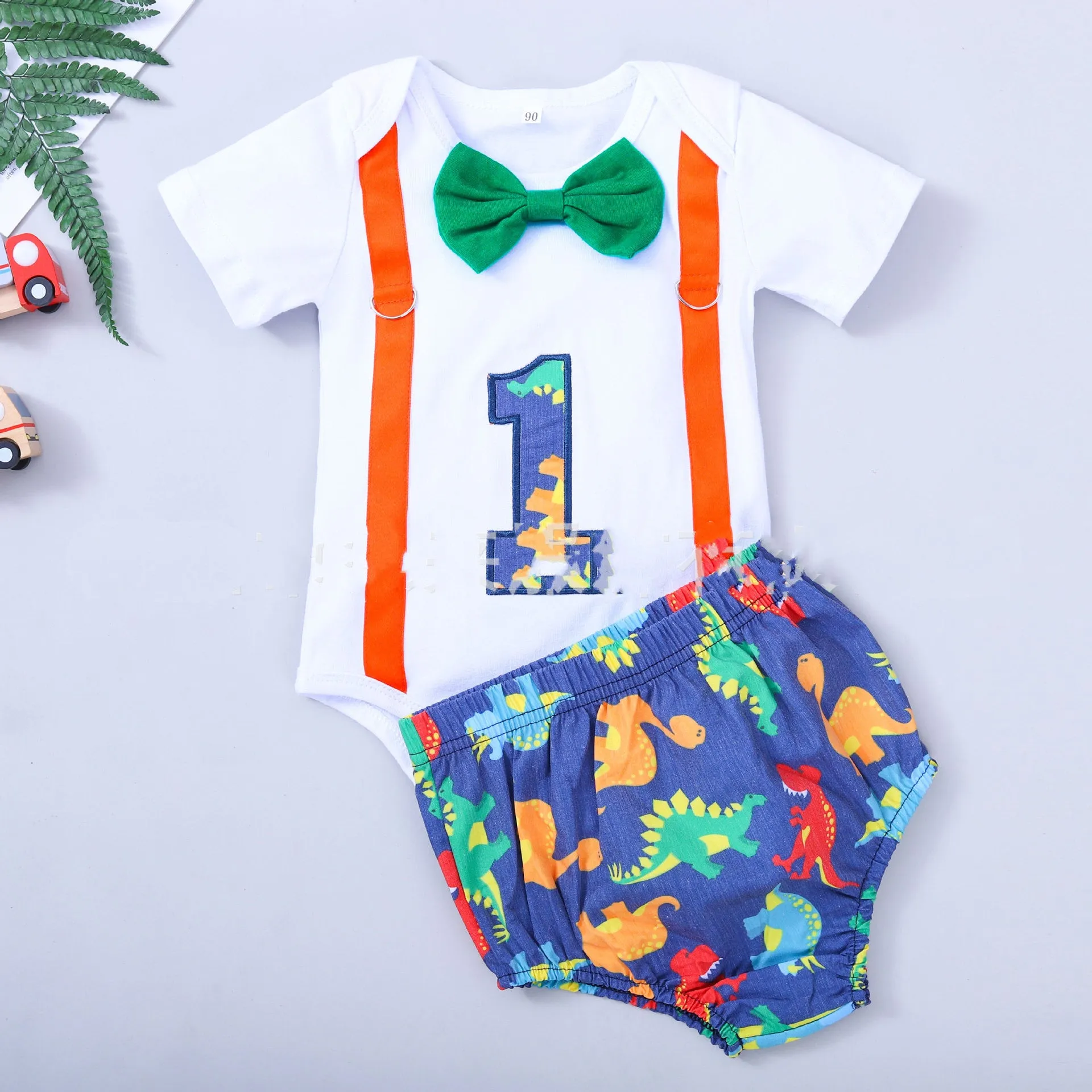 Cotton baby romper set with dinosaur print in blue or green, shorts length with ruffles and straps
