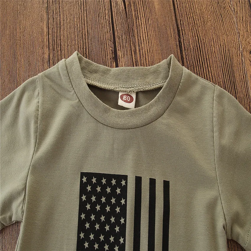 Little boy wearing a US flag camouflage print short-sleeved shirt and matching trousers.