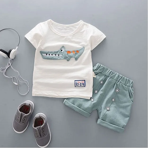 Baby boy wearing a blue cotton short sleeve T-shirt and matching shorts summer outfit set.