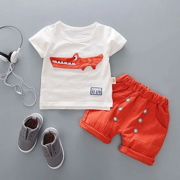 Baby boy wearing a blue cotton short sleeve T-shirt and matching shorts summer outfit set.