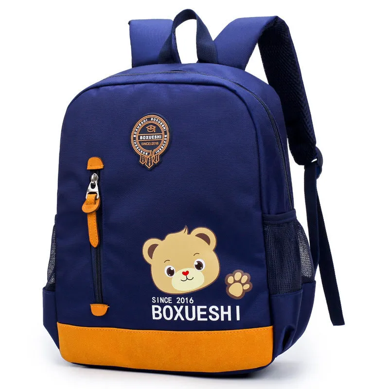 Blue nursery backpack with a cartoon bear design, showing front zip pocket and adjustable padded straps.