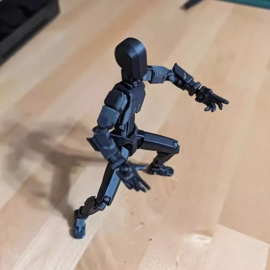 Unassembled 3D printed robot model kit with multi-jointed parts on a table