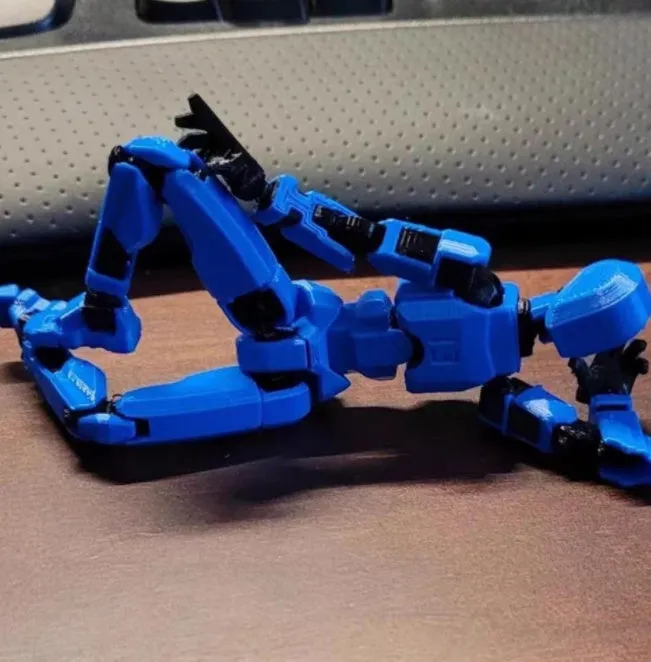 Unassembled 3D printed robot model kit with multi-jointed parts on a table