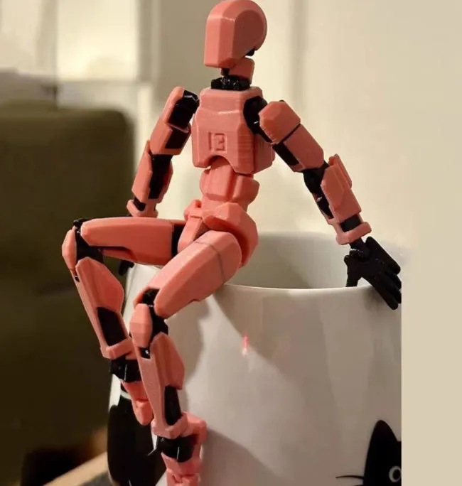 Unassembled 3D printed robot model kit with multi-jointed parts on a table