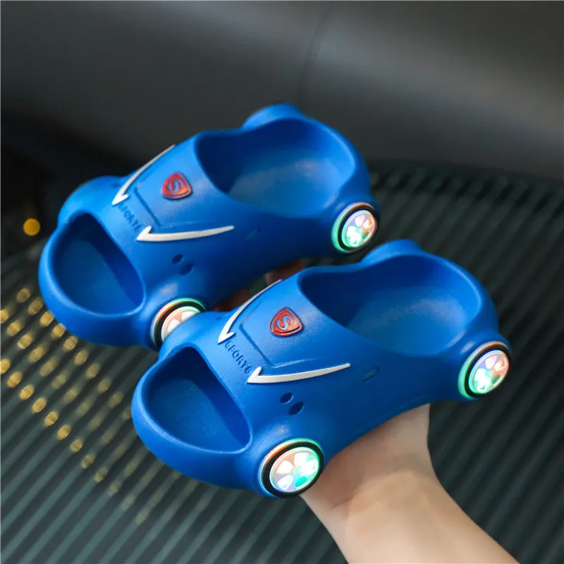 Children's luminous cartoon car design sandals with anti-slip soles on a blue background.