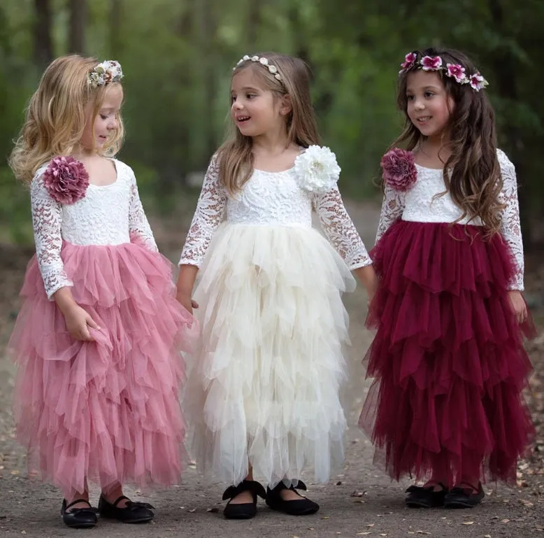 White long-sleeved lace princess dress for girls with an irregular hemline, shown on a hanger.