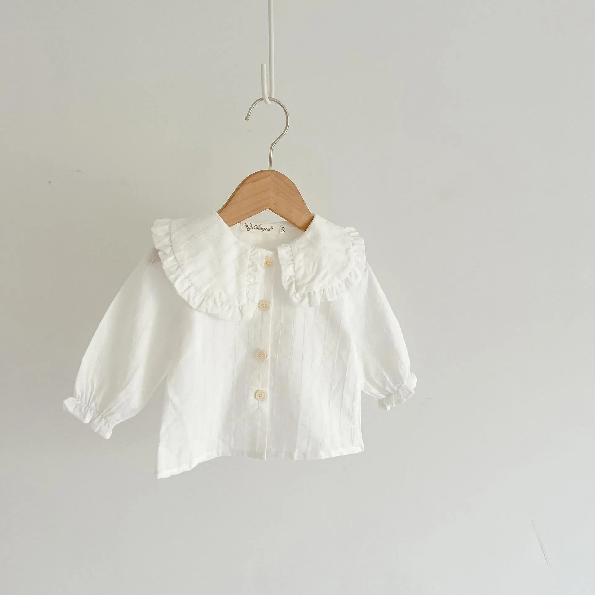 Apricot coloured baby girl's cotton romper with white top, adjustable suspenders, and mid-waist trousers.