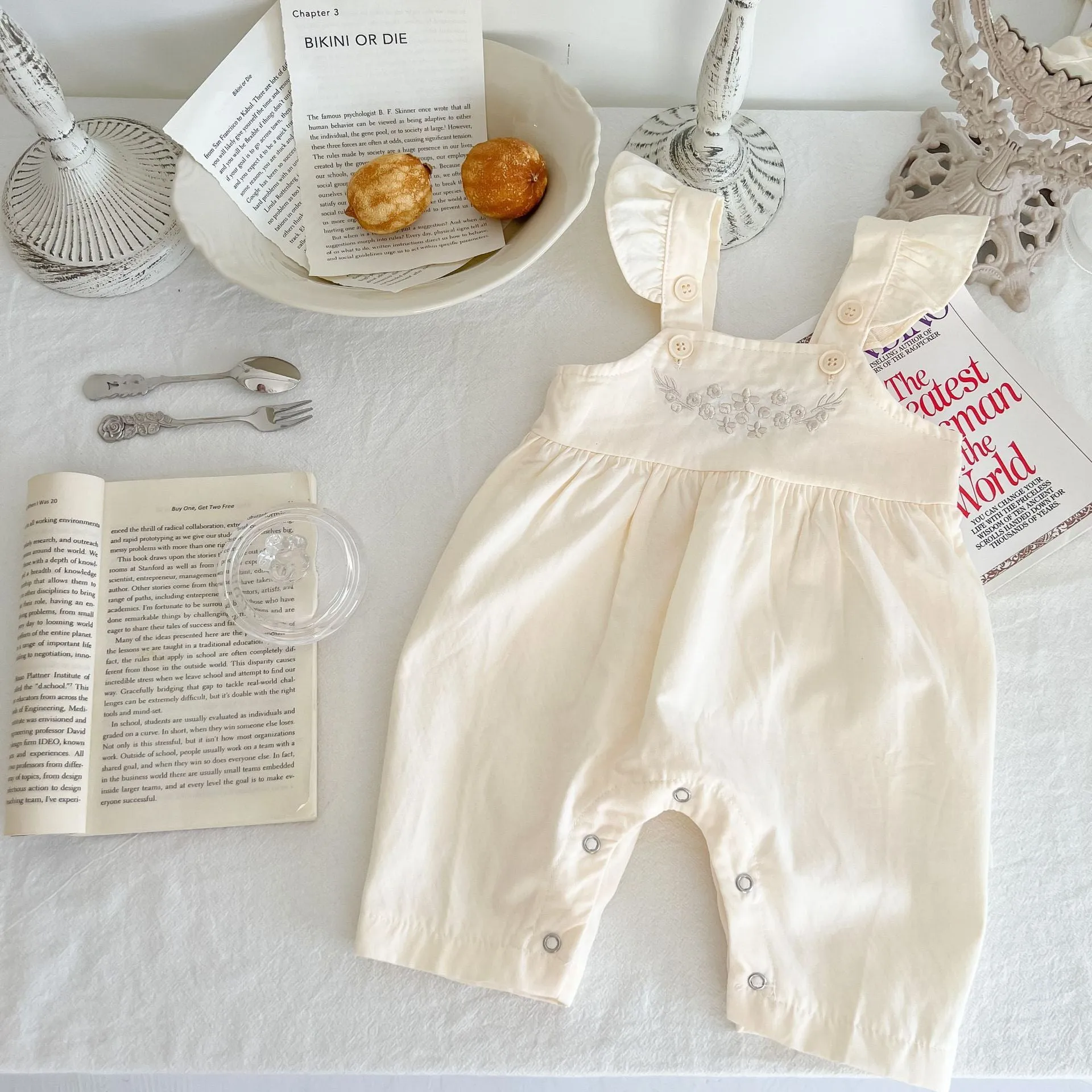 Apricot coloured baby girl's cotton romper with white top, adjustable suspenders, and mid-waist trousers.