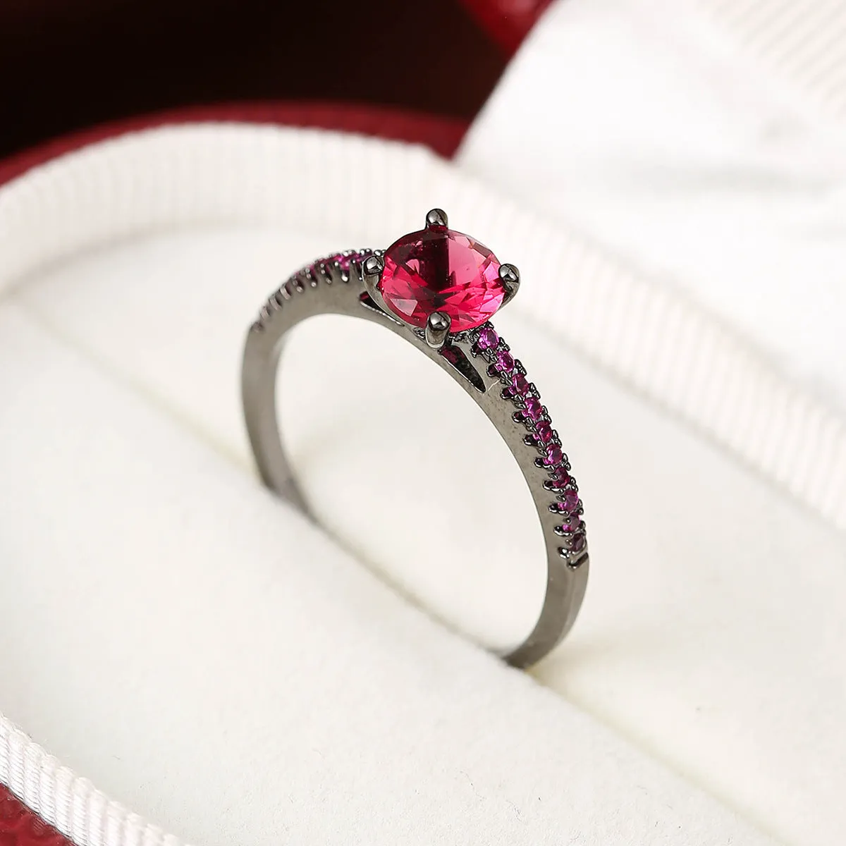 Hexagonal geometric zircon ring in copper with an electroplated gun black purple finish on a finger.