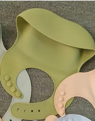 Soft waterproof silicone baby bib with food catcher in pink, with adjustable neck closure