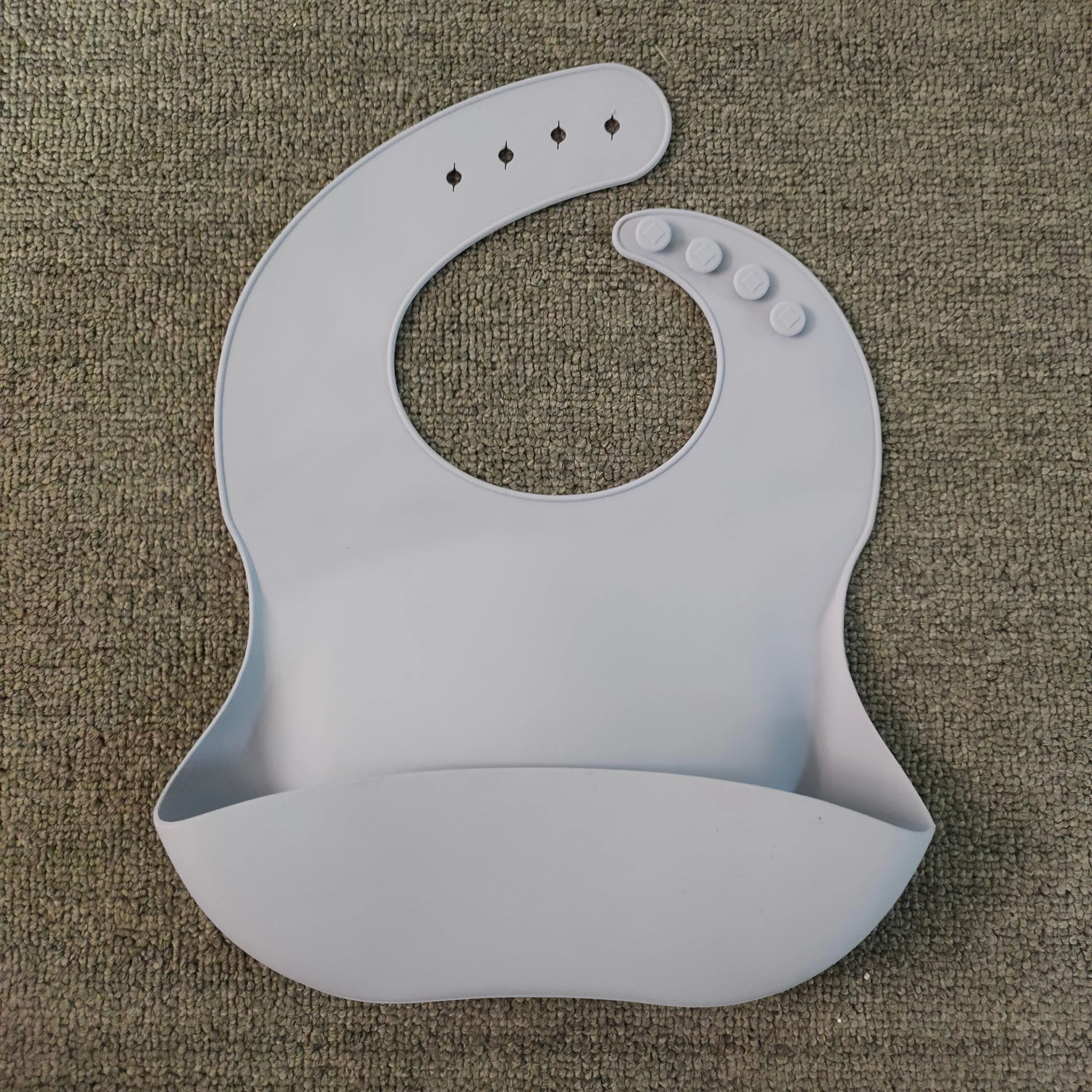 Soft waterproof silicone baby bib with food catcher in pink, with adjustable neck closure
