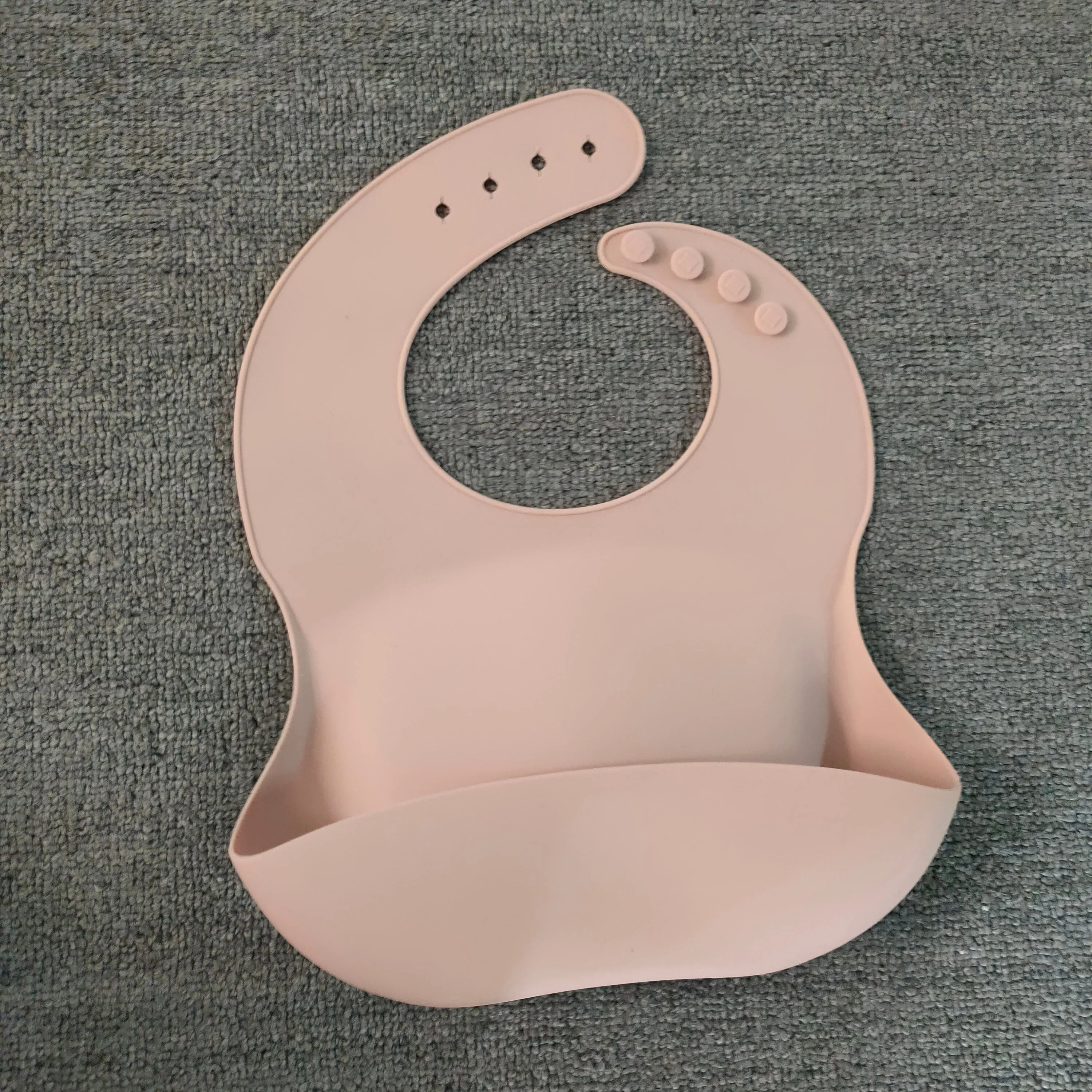 Soft waterproof silicone baby bib with food catcher in pink, with adjustable neck closure