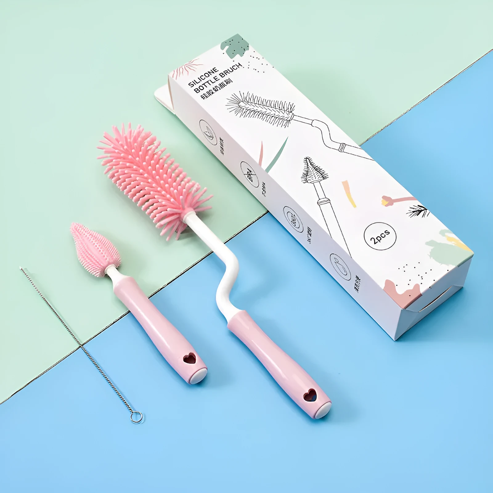 Three silicone baby bottle brushes in blue, pink, and yellow with straw scrubber on white background