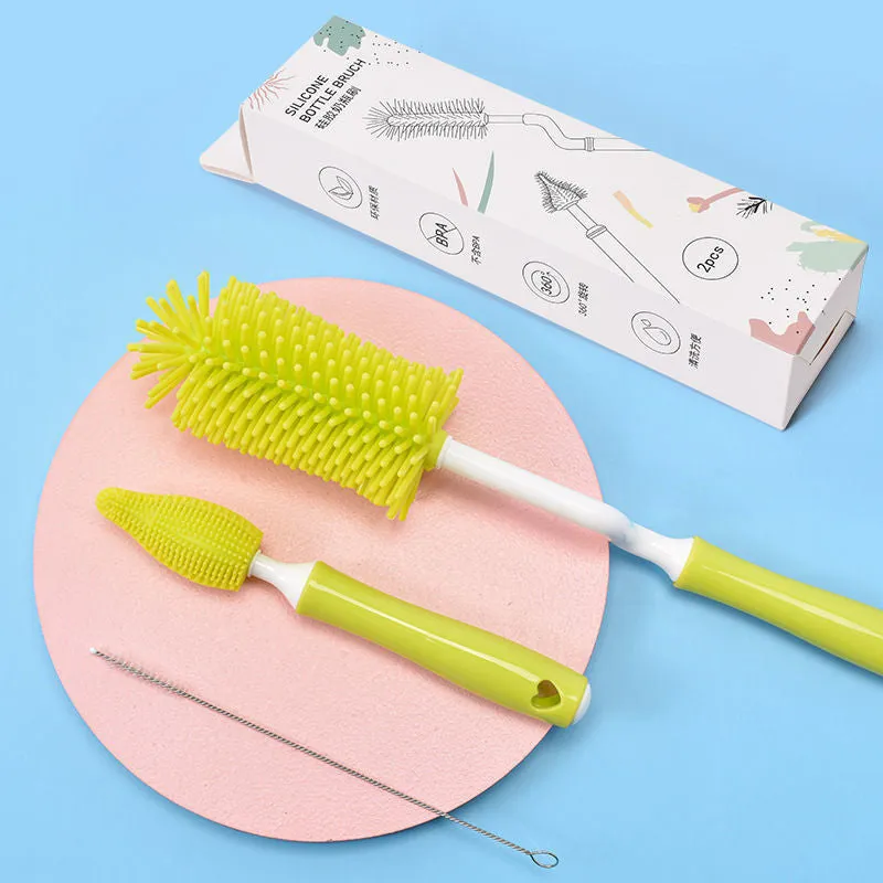 Three silicone baby bottle brushes in blue, pink, and yellow with straw scrubber on white background