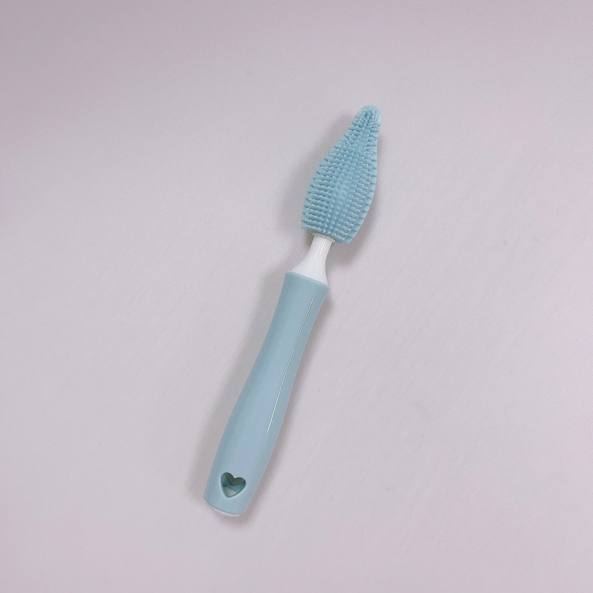 Three silicone baby bottle brushes in blue, pink, and yellow with straw scrubber on white background