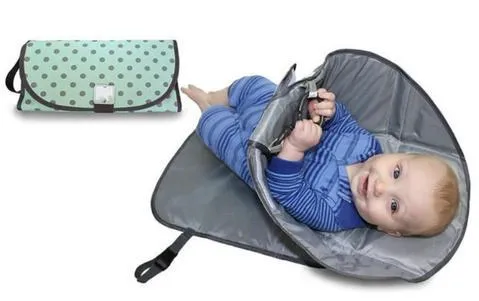 Portable baby diaper changing mat in yellow geometric pattern, 70x50cm, with toy ring and wrist strap unfolded on floor
