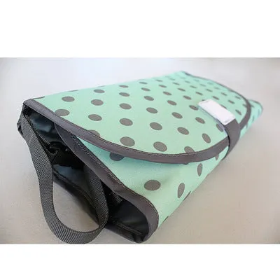 Portable baby diaper changing mat in yellow geometric pattern, 70x50cm, with toy ring and wrist strap unfolded on floor