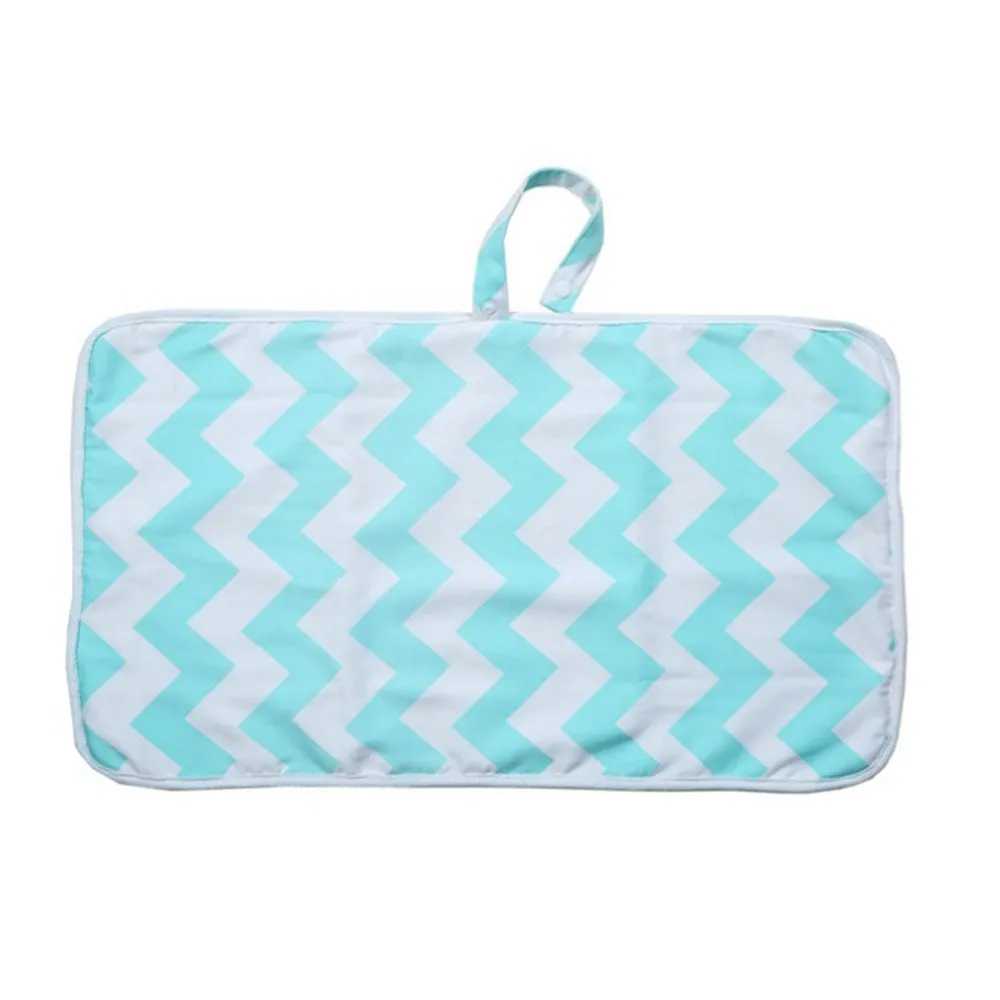 Portable baby diaper changing mat in yellow geometric pattern, 70x50cm, with toy ring and wrist strap unfolded on floor