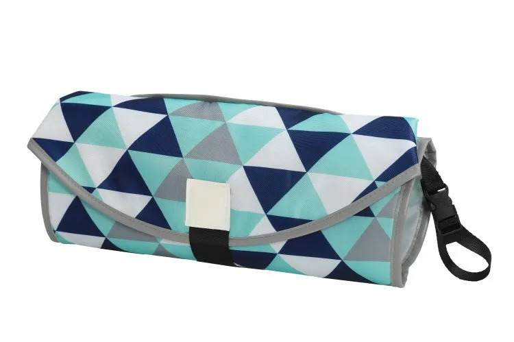 Portable baby diaper changing mat in yellow geometric pattern, 70x50cm, with toy ring and wrist strap unfolded on floor