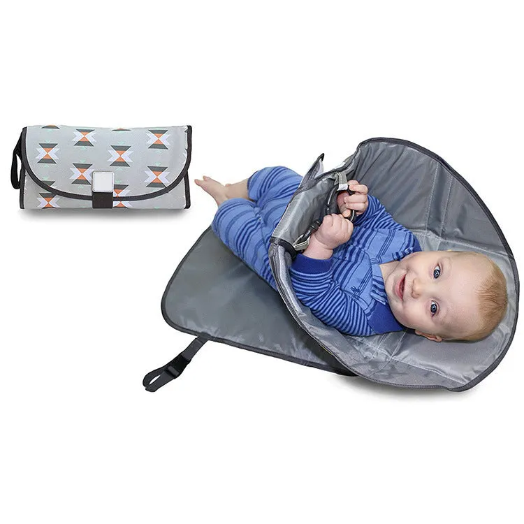 Portable baby diaper changing mat in yellow geometric pattern, 70x50cm, with toy ring and wrist strap unfolded on floor