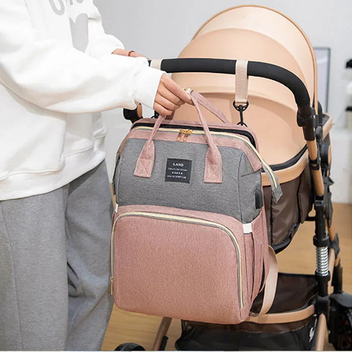 Large capacity insulated baby crib backpack in pink grey with double shoulder straps and outer pocket on white background