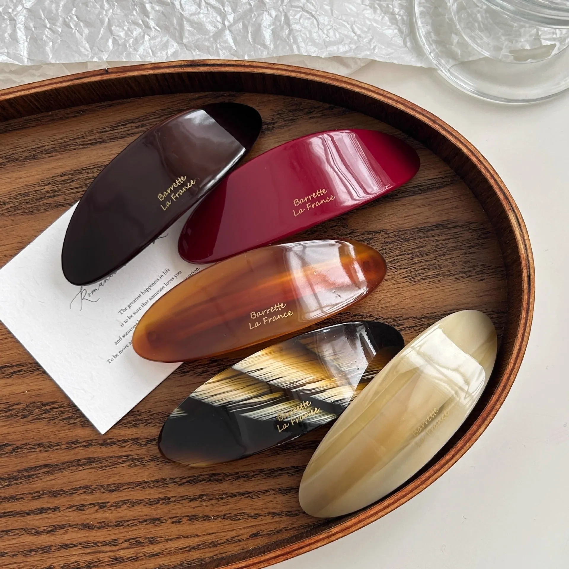 Mingshangjia acetic acid oval low ponytail hairpin in wine red colour on a plain background