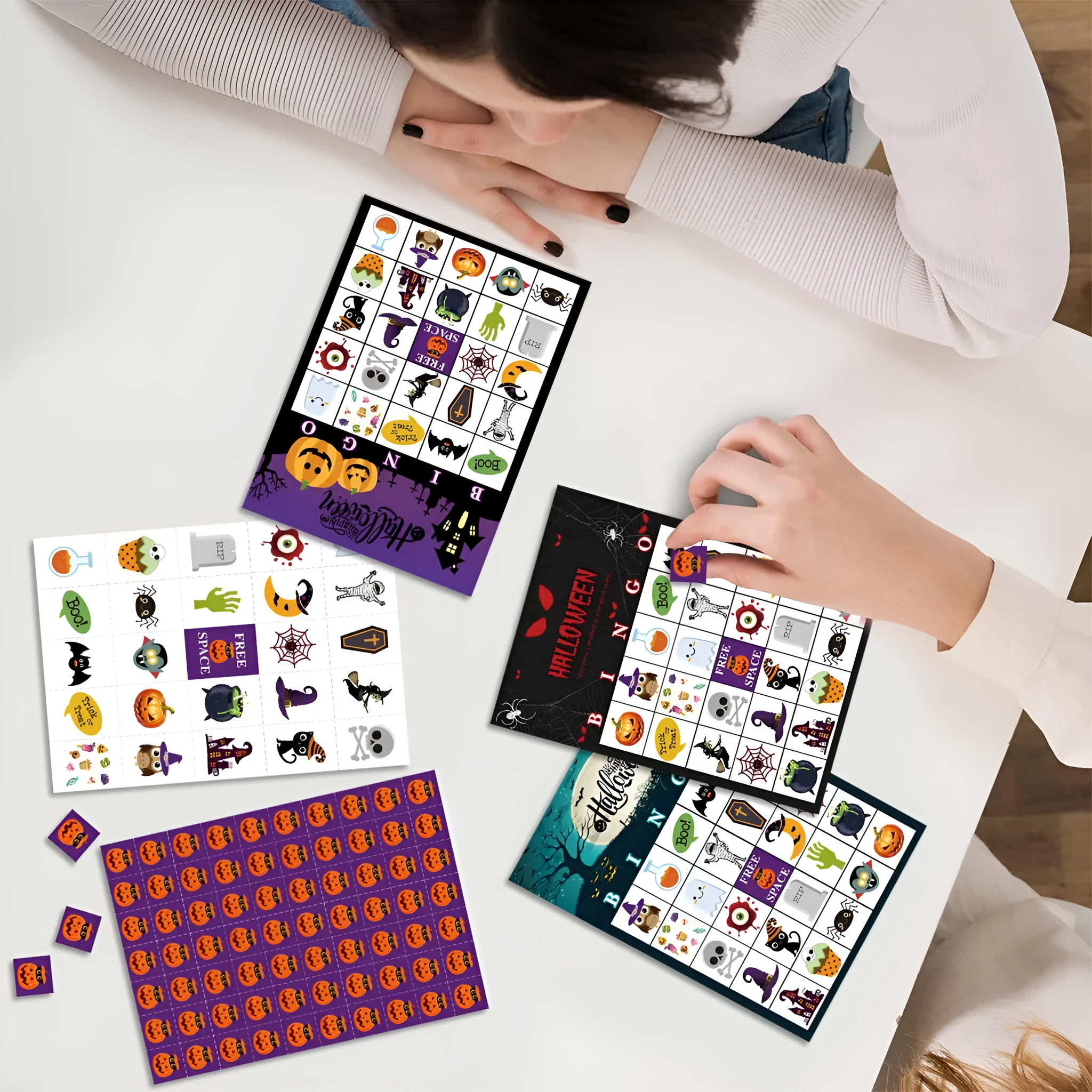 Halloween pumpkin bingo game cards on a table, paper set measuring 13x18 cm