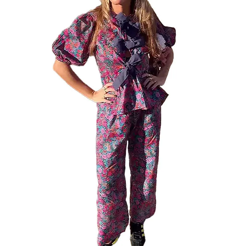 Women's floral print trouser suit with puff sleeves and tie-neck top, coordinating trousers