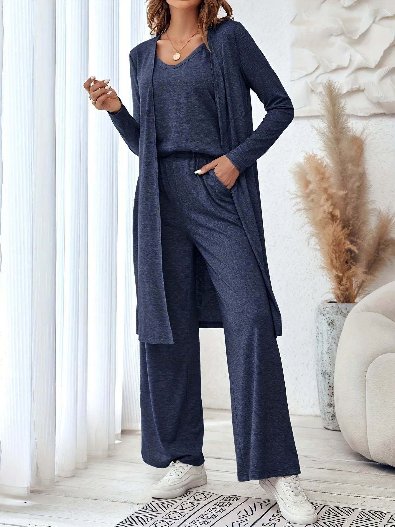Blue women's three-piece casual suit with sling top, long cardigan, and trousers on a hanger.