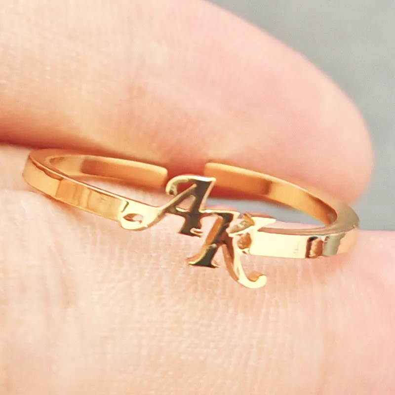 Customised 2 letters open ring in stainless steel with gold electroplated finish on a plain background